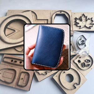 May include: A blue leather wallet with white stitching is held in a hand. Various wooden craft dies surround the wallet, featuring shapes like circles, leaves, and geometric designs. The wallet has a textured surface.