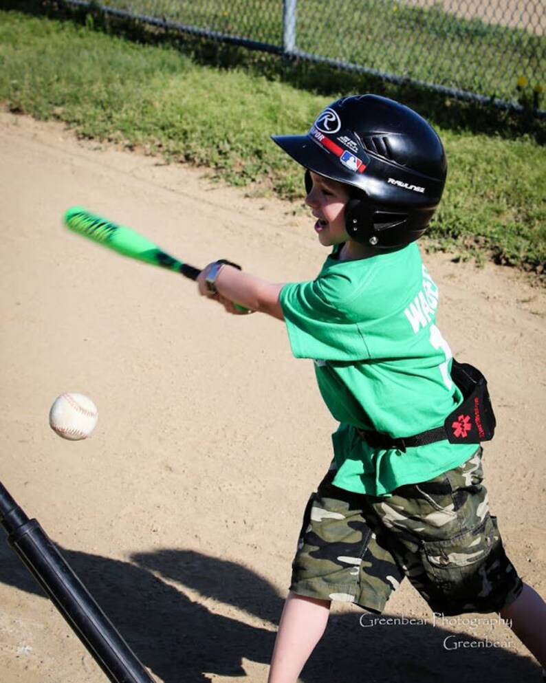 Boy playing baseball wearing his Alert Wear case.