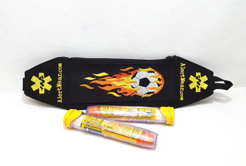 Black Alert Wear Medicine Case with Soccer Ball and Yellow and Orange Flames. Yellow Medical Alert Symbols on sides.