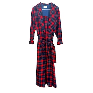 May include: A long, red and navy blue plaid robe with a matching belt. The robe has long sleeves and a shawl collar. The interior lining is a solid navy blue. The robe is hanging on a white hanger.