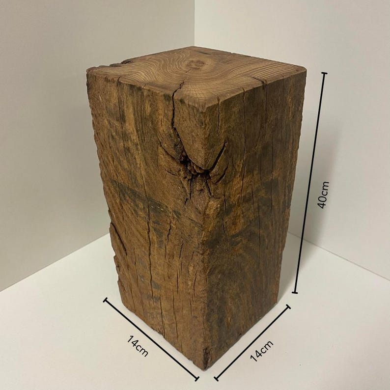May include: A square-cut wooden block with a natural brown finish, visible wood grain, and a prominent knot on one side. The block measures 14 cm by 14 cm by 40 cm, as indicated by the black dimension lines and text printed on the image.