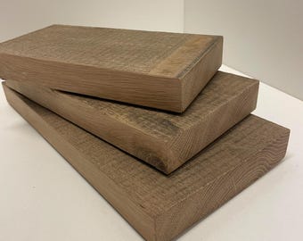 Könnte beinhalten: Drei rechteckige Holzbretter, die versetzt übereinander gestapelt sind. Jedes Brett weist eine natürliche hellbraune Holzmaserung mit sichtbarer Textur und geraden Kanten auf. Die Bretter sind vom kleinsten oben bis zum größten unten angeordnet.