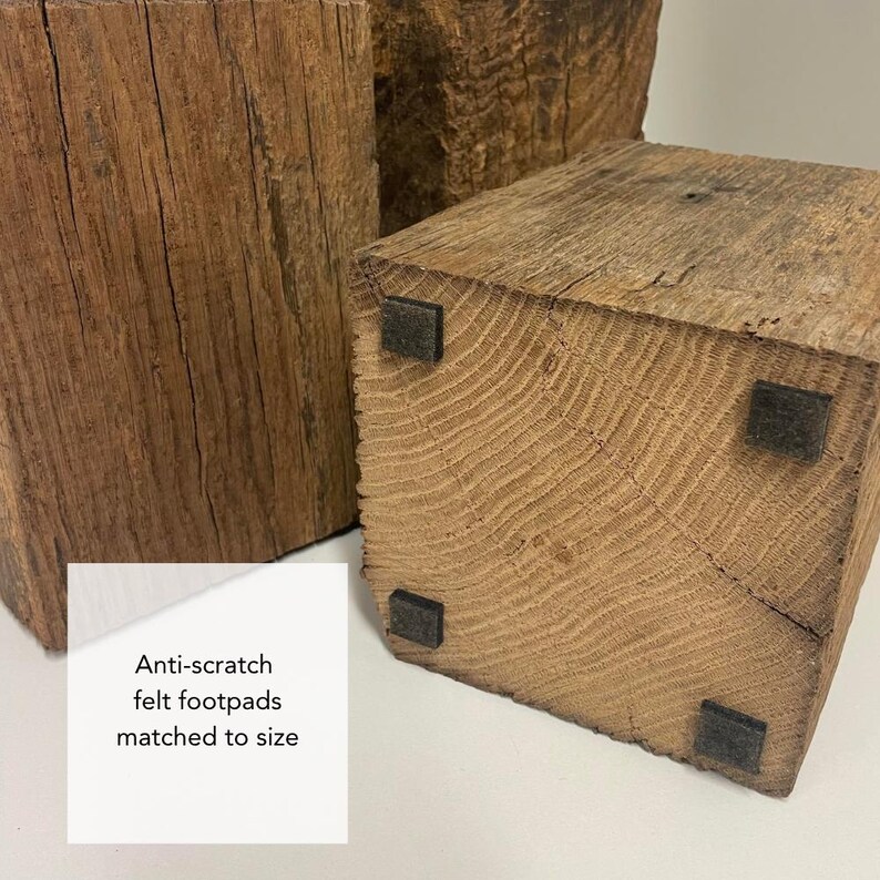 May include: Two rectangular blocks of weathered brown wood with visible grain and texture. The base of the foreground block features four small, square, black anti-scratch felt footpads. A white label with the text Anti-scratch felt footpads matched to size.
