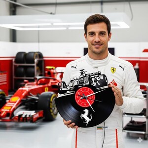 Op de afbeelding: Een zwarte vinylplaatklok met een Formule 1-raceauto-ontwerp. De klok heeft een rode wijzerplaat met witte cijfers en wijzers. Het Ferrari-logo is zichtbaar. De klok wordt vastgehouden door een persoon in een wit racepak.