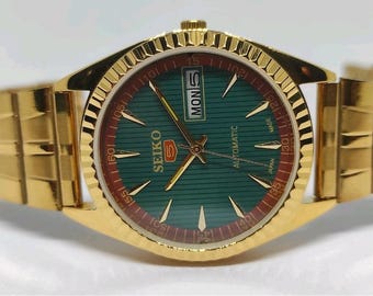 Reloj de pulsera automático Seiko 5 reacondicionado con esfera verde y caja chapada en oro.