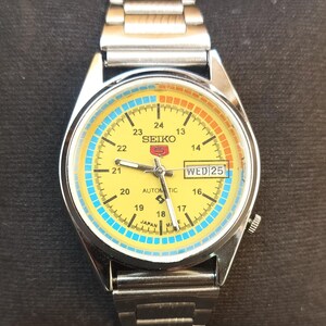 Reloj Seiko 5 automático vintage reacondicionado con esfera amarilla y fecha, marca japonesa.