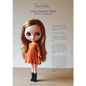 May include: A doll wearing a long-sleeved orange dress with a gathered skirt. The dress pattern is for Blythe and iMda dolls. The text on the page reads "Tirin & Katten Long sleeved dress for Blythe and iMda dolls".