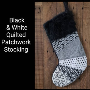 May include: A black and white quilted patchwork Christmas stocking with a faux fur cuff. The stocking features various patterned fabric panels, including floral, geometric, and swirl designs. The text "Black & White Quilted Patchwork Stocking" is on the left.