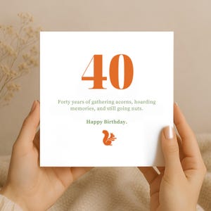 Puede incluir: Una tarjeta de felicitación de cumpleaños cuadrada y blanca con el número 40 grande en naranja en la parte superior. Debajo del número, el texto dice: Forty years of gathering acorns, hoarding memories, and still going nuts. Happy Birthday. Un pequeño icono de ardilla naranja.