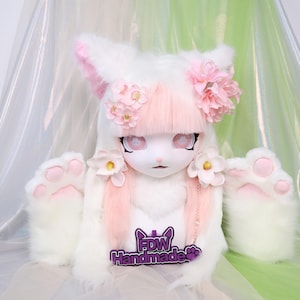 May include: A white and pink furry costume head with large ears, pink accents, and flower decorations. The costume has large, expressive eyes and is paired with matching paw-shaped mittens. The logo "FDW Handmade" is visible.