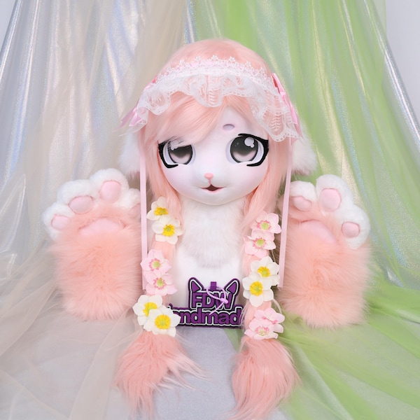 Cabeça de fursuit KIG de cordeiro rosa com olhos pretos, pelo macio e fofo no pescoço com um toque de blush, acessórios românticos com laço de renda e luvas de pata combinando em tons pastel.