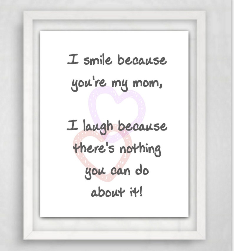 May include: A framed print with the text "I smile because you're my mom, I laugh because there's nothing you can do about it!" in black script. Two overlapping heart shapes in pink and purple accent the text.