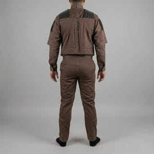 Op de afbeelding: Een set van drie keramische mokken met een gespikkelde, matte afwerking. De mokken zijn in cr&egrave;me, lichtgrijs en donkergrijs. Elke mok heeft een eenvoudig, minimalistisch ontwerp.