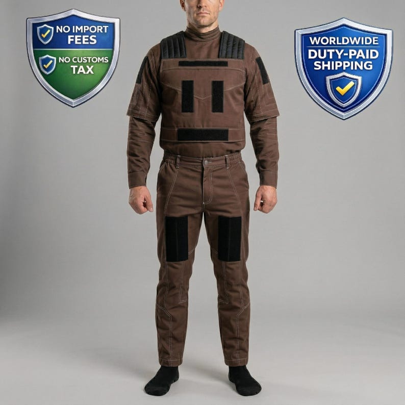 Op de afbeelding: Een bruin beschermend pak met zwarte vulling op de schouders, borst en knie&euml;n. Het pak bestaat uit een top met lange mouwen en een broek. De afbeelding toont ook twee schilden met tekst: "NO IMPORT FEES, NO CUSTOMS TAX" en "WORLDWIDE DUTY-PAID SHIPPING."
