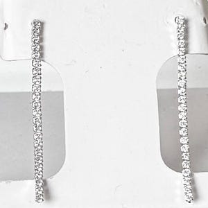 May include: A pair of Giani Bernini silver-toned earrings, each featuring a linear design of small, sparkling stones. The earrings are displayed in a black and white branded box with the Giani Bernini logo.