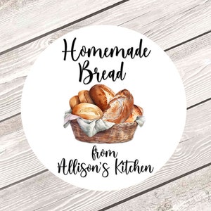 May include: White round sticker with black text that reads "Homemade Bread from Allison's Kitchen". A watercolor illustration of a basket of various loaves of bread is in the center of the sticker.