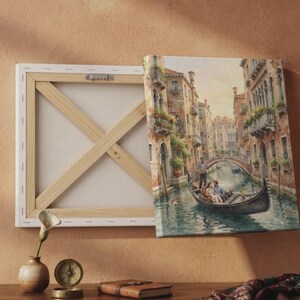 May include: A rectangular canvas print featuring a painting of a Venetian canal scene with a gondola, passengers, and a gondolier. The canvas is shown from the back, revealing a wooden stretcher frame with cross-bracing and metal hardware.