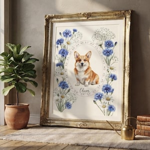 May include: A framed print featuring a central illustration of a tan and white Corgi dog inside an oval border. The dog is surrounded by blue cornflowers and white daisies. The name Oliver is printed below the dog in a cursive script font.