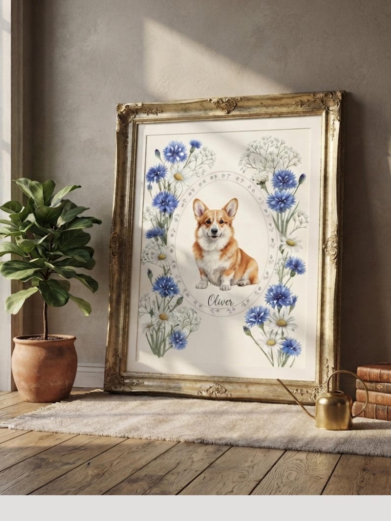 May include: A framed print featuring a central illustration of a tan and white Corgi dog inside an oval border. The dog is surrounded by blue cornflowers and white daisies. The name Oliver is printed below the dog in a cursive script font.