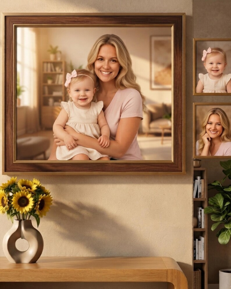 May include: A large rectangular wall mirror with a dark wood frame featuring a gold inner trim. The mirror reflects a woman holding a baby, both smiling. Two smaller framed portraits of the same subjects are mounted on the wall to the right.