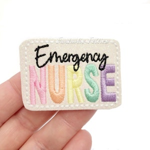 May include: White felt patch with a rainbow embroidered word "NURSE" and the word "Emergency" written in black above it.
