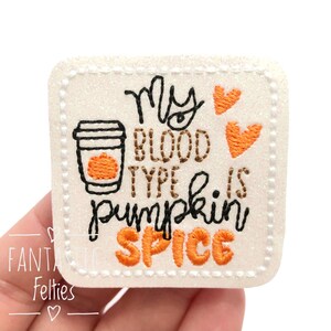 May include: White felt patch with orange and brown embroidery. The text reads "My blood type is pumpkin spice" with a coffee cup and two hearts.