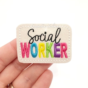 May include: White glitter iron-on patch with the text "Social Worker" in black outlined letters. The letters in "Worker" are in rainbow colors: pink, blue, yellow, green, and purple.