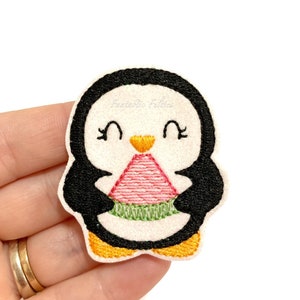 May include: Embroidered penguin applique with a white background, black and white body, yellow beak, and holding a pink and green watermelon slice.
