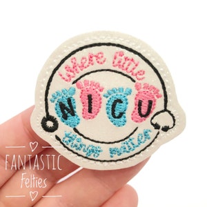 May include: A white embroidered patch with the text "Where little things matter" and "NICU" in blue and pink. The patch features baby footprints and a black outline.