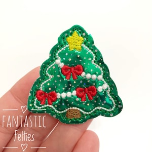 May include: A green felt Christmas tree with white and red felt decorations. The tree has a yellow felt star on top.