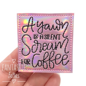 May include: A pink iridescent square patch with black embroidery that reads "A yawn is a silent scream for coffee".