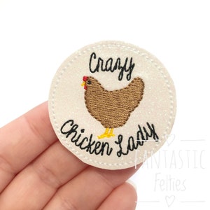 May include: A white, round, glittery felt patch with black embroidery that reads "Crazy Chicken Lady". A brown chicken with a red comb is embroidered in the center of the patch.