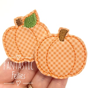 May include: Two pumpkin-shaped felt appliqués featuring an orange and white gingham pattern. Each pumpkin has a brown embroidered stem, and one includes a green embroidered leaf. The edges are finished with orange stitching.