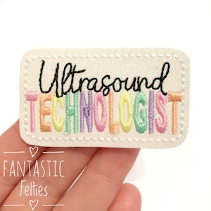 May include: White felt patch with rainbow colored embroidery that reads "Ultrasound Technologist".