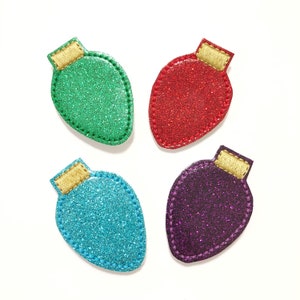 May include: Four sparkly Christmas light ornaments in green, red, blue, and purple. Each ornament has a gold top.