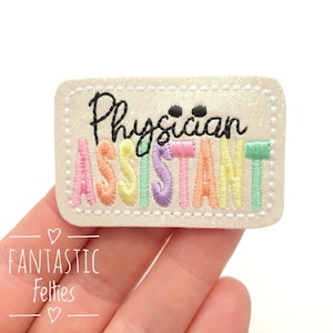 May include: A white felt patch with a rainbow-colored embroidered word "Assistant" and the word "Physician" written in black cursive above it.