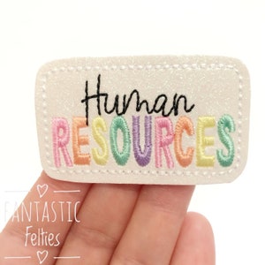 May include: A white felt patch with a rainbow-colored embroidered word "HUMAN RESOURCES" in a rectangular frame.