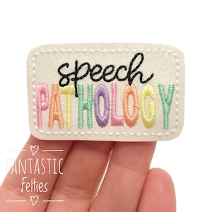 May include: White felt patch with the words "speech pathology" embroidered in rainbow colors. The words "speech" are in black.