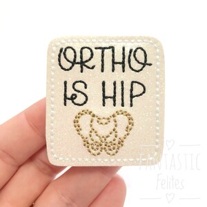 May include: White glitter iron-on patch with black stitching and the text "Ortho is Hip" with a gold embroidered hip bone.