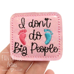 May include: A pink square patch with the text "I don't do Big People" in black script. The patch features embroidered baby footprints in pink and blue. The patch is from Fantastic Felties.