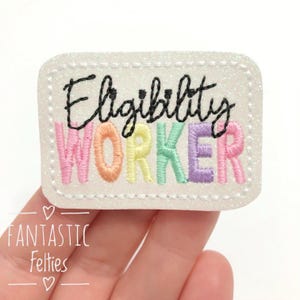 May include: White glitter iron-on patch with the text "Eligibility Worker" in rainbow colors. The word "Eligibility" is in black and the word "Worker" is in rainbow colors.