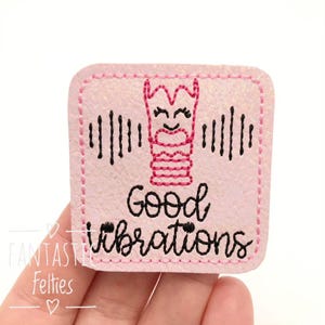 May include: A pink square patch with a stitched border features a cartoon larynx design in pink and black, with sound wave lines. The words "Good vibrations" are written in black script.