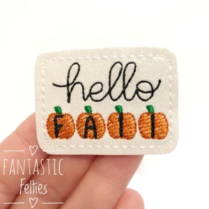 May include: White felt patch with the text "hello" and four orange pumpkins spelling out "fall".