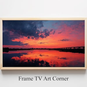 Peut inclure: Une impression encadrée d'un coucher de soleil sur l'eau. Le ciel est un mélange d'orange, de rouge et de bleu foncé, reflété dans l'eau. Une silhouette de pont est visible au loin. Le cadre est en bois clair.