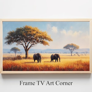 Puede incluir: Pintura de paisaje enmarcada que representa dos elefantes en un entorno de sabana. La obra presenta un campo dorado, árboles con follaje amarillo-anaranjado y un cielo azul. El texto "Frame TV Art Corner" está en la parte inferior.