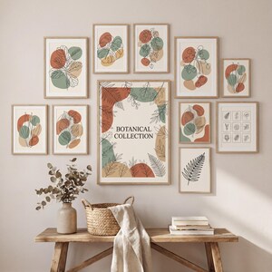 Peut inclure: Une collection d'estampes botaniques encadrées de différentes tailles. Les estampes présentent des dessins au trait abstraits de feuilles et de plantes dans des couleurs sourdes comme la rouille, le vert sauge et le beige. Le texte central est "BOTANICAL COLLECTION."