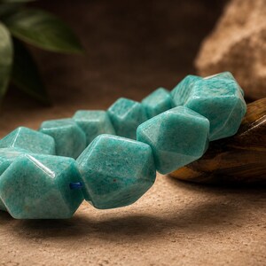 Pu&ograve; includere: Un bracciale composto da perline geometriche sfaccettate di un vibrante colore verde acqua. Le perline hanno una finitura liscia e lucida e sono infilate su un sottile cordino blu, creando un aspetto strutturato e angolare sull'intero pezzo.