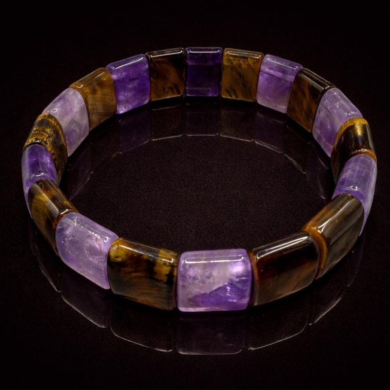 May include: A bracelet featuring rectangular beads in shades of purple and brown. The alternating colors create a striking contrast, with the purple beads appearing translucent. The bracelet is designed to be worn around the wrist.