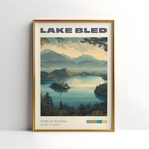 May include: A framed print depicting Lake Bled in Slovenia. The image shows a tranquil lake with an island church, framed by trees and mountains. The text "LAKE BLED" is at the top, with "PEARL OF SLOVENIA" and coordinates at the bottom.