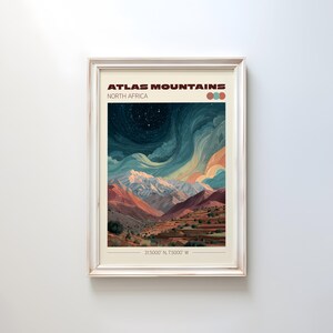May include: Framed art print featuring a landscape of the Atlas Mountains in North Africa. The artwork depicts a mountain range under a starry night sky with a color palette of blues, oranges, and reds. Text at the top reads "ATLAS MOUNTAINS NORTH AFRICA".
